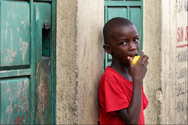 Un niño come algo de fruta en Kenia. Fotografía: Marta Carreño.