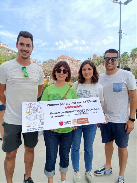 Recogida del cheque de manos de la directora del centro educativo, junto con dos profesores y la representante de Manos Unidas en Alacuás, Clara Sarrió.