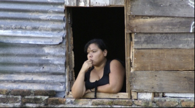 Manos Unidas - En Honduras, los activistas y los jóvenes pobres corren serio peligro - Un joven hondureña mira al horizonte desde su ventana